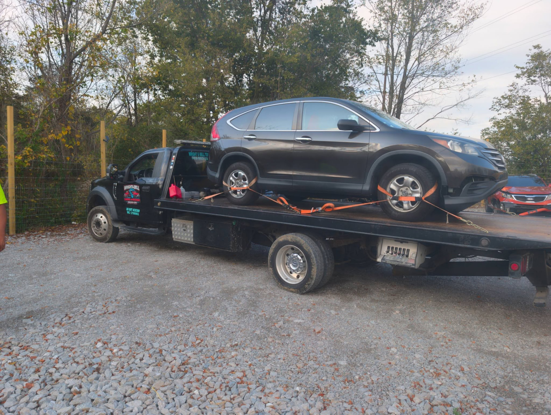 An SUV loaded on the flatbed in a parking lot